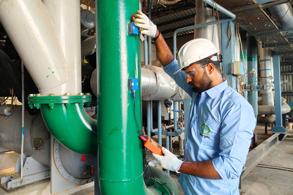 Energeia engineer in safety uniform using a flow meter on the HVAC piping system